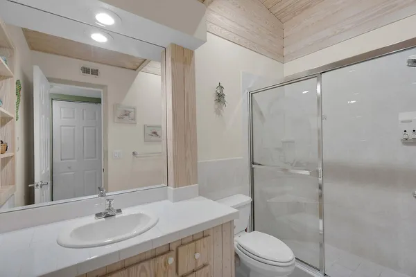 a bathroom with a sink toilet a mirror and shower