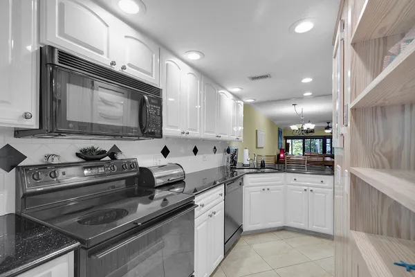 a kitchen with granite countertop a stove sink and cabinets