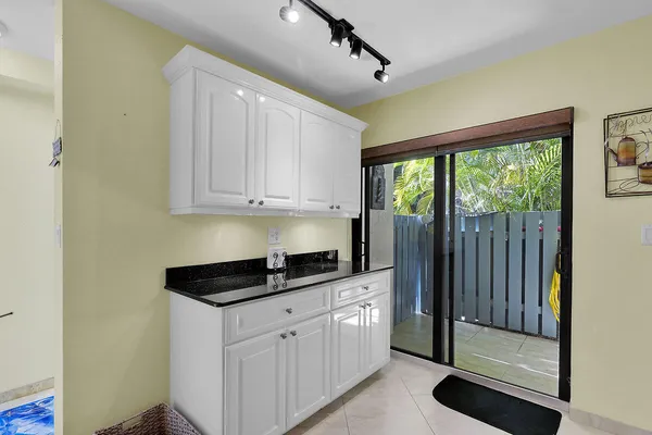 a kitchen with granite countertop a stove a sink and a refrigerator