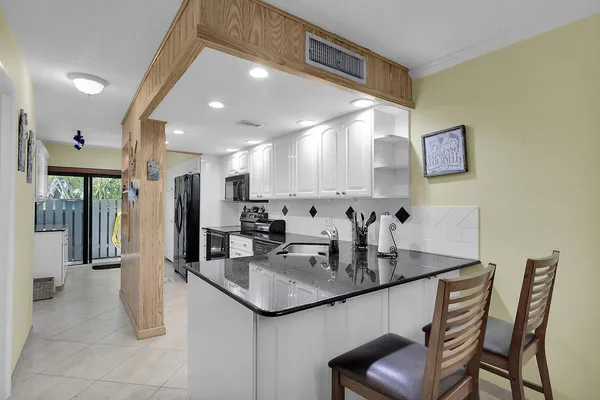 a kitchen with stainless steel appliances granite countertop a sink and a refrigerator