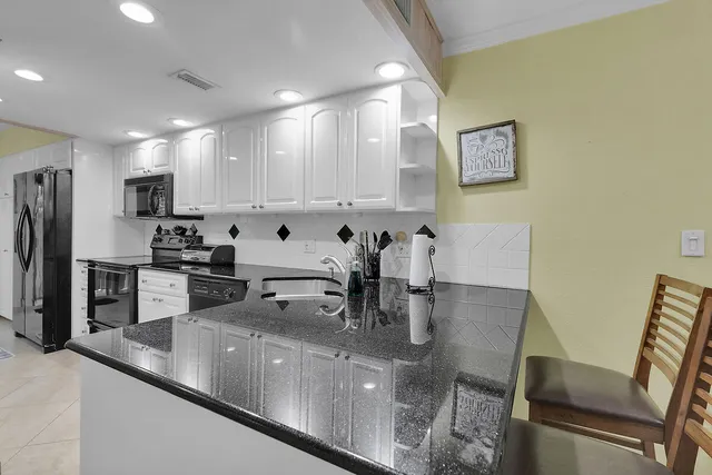 a kitchen with kitchen island a counter top space cabinets and stainless steel appliances