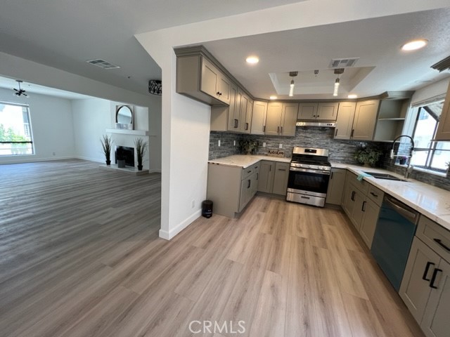 517 North Curtis Avenue, Unit E Alhambra, CA 91801 - Photo 10 of 34 a large kitchen with stainless steel appliances granite countertop a stove top oven a sink dishwasher and a fireplace with wooden floor