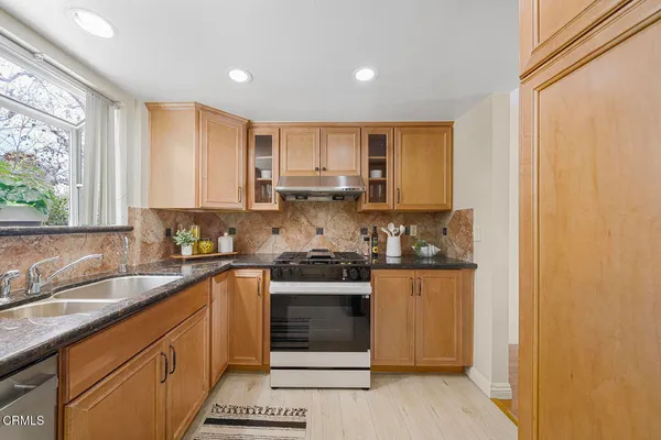 a kitchen with stainless steel appliances granite countertop a refrigerator and a stove
