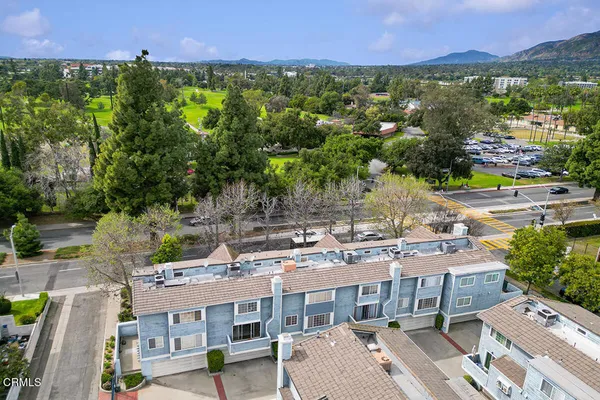 a sign of golf club on a wall under a tree