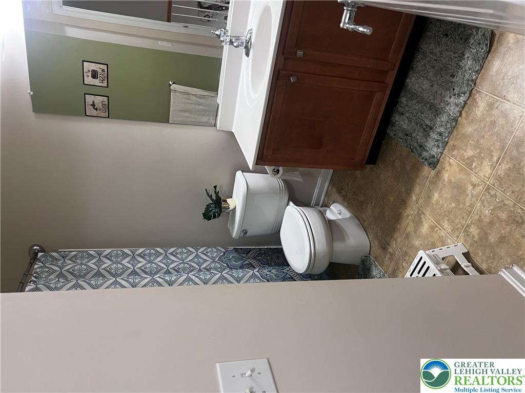 8549 Gateway Road Breinigsville, PA 18031 - Photo 23 of 26 Tiled flooring complements a classic vanity and commode in this well-appointed bath.