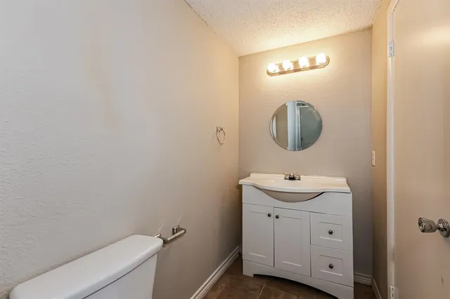 a bathroom with a toilet a sink and mirror