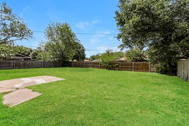 a view of a yard with grass and trees