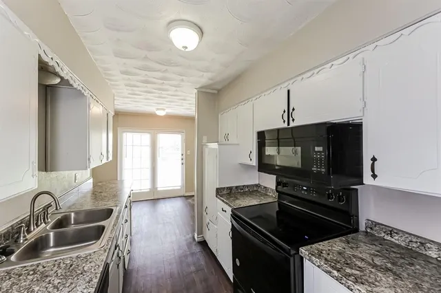 a kitchen with granite countertop a stove and a sink