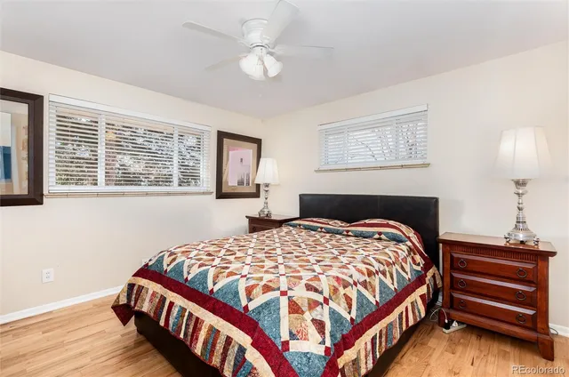 a bedroom with a bed a dresser with wooden floor