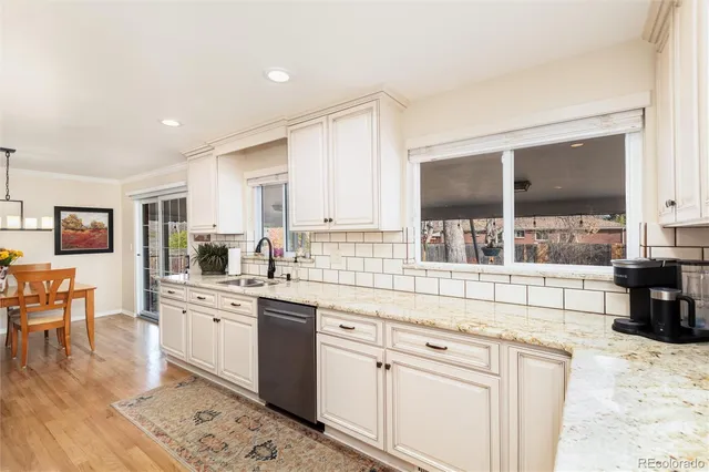 a kitchen with white cabinets and sink