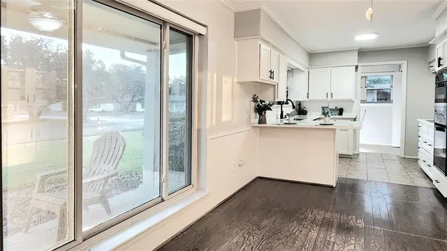 a kitchen with a refrigerator and white cabinets