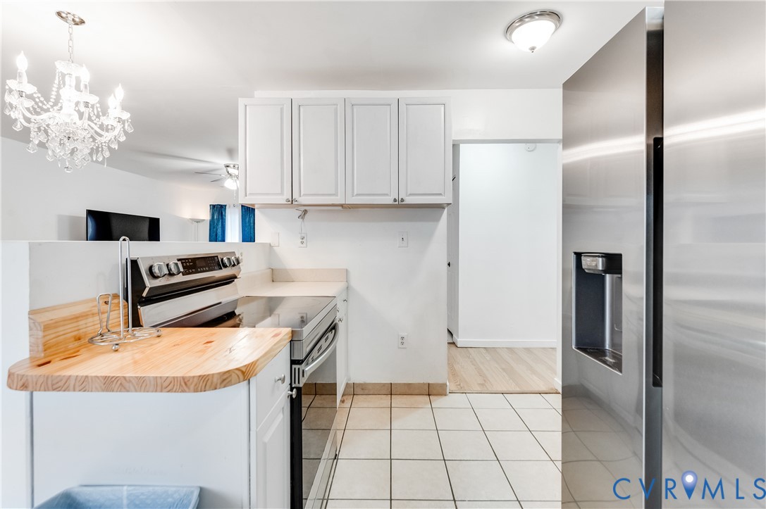 5724 Linda Road Sandston, VA 23150 - Photo 15 of 35 a kitchen with stainless steel appliances granite countertop a refrigerator a stove and white cabinets with wooden floor