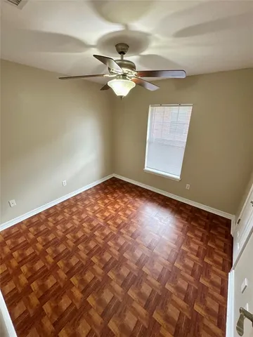 a view of a big room with a chandelier fan and windows