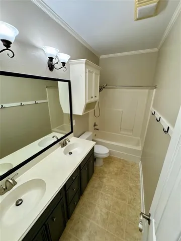 a bathroom with a double vanity sink mirror and toilet