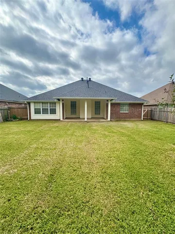a view of a house with a big yard and large trees