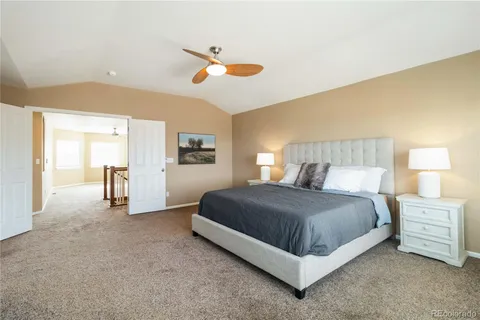 a spacious bedroom with a bed and ceiling fan
