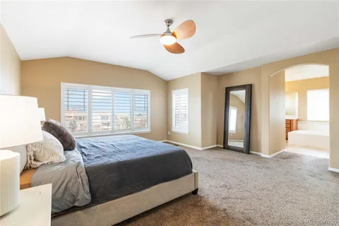 a bedroom with a large bed and a chandelier