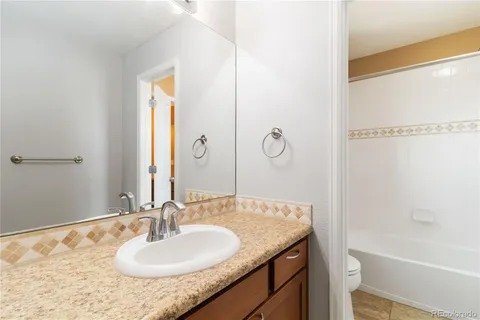 a bathroom with a granite countertop sink and a mirror