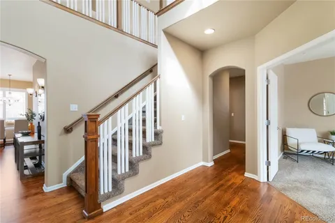 a view of a hallway with wooden floor and staircase
