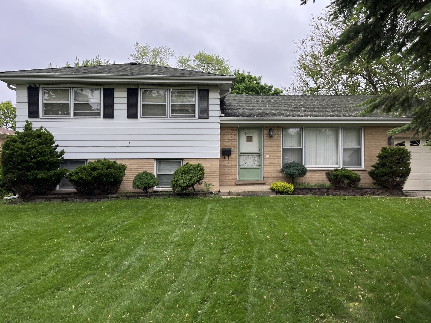 1602 West Willow Lane Mount Prospect, IL 60056 - Photo 2 of 4 a backyard of a house with potted plants and wooden fence