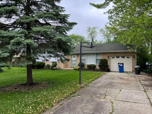 a front view of a house with a yard and trees