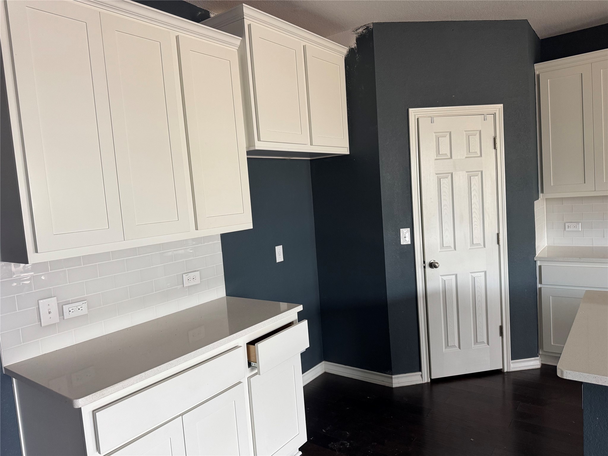 333 Capstone Road Liberty Hill, TX 78642 - Photo 12 of 40 Kitchen with backsplash, white cabinetry, and dark wood-style flooring