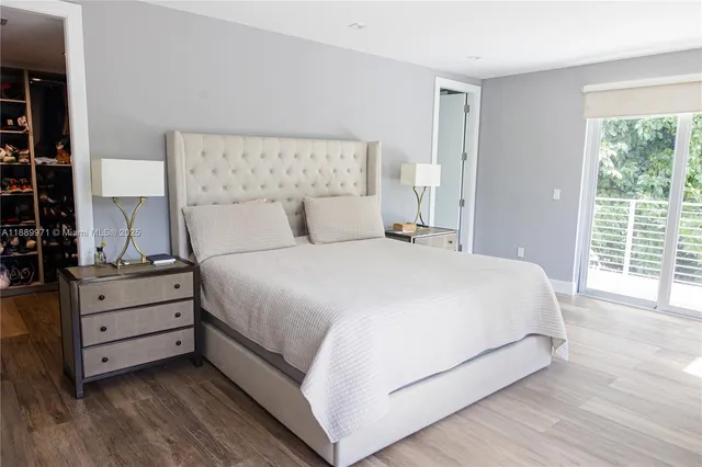 a large bed sitting in a bedroom next to a window