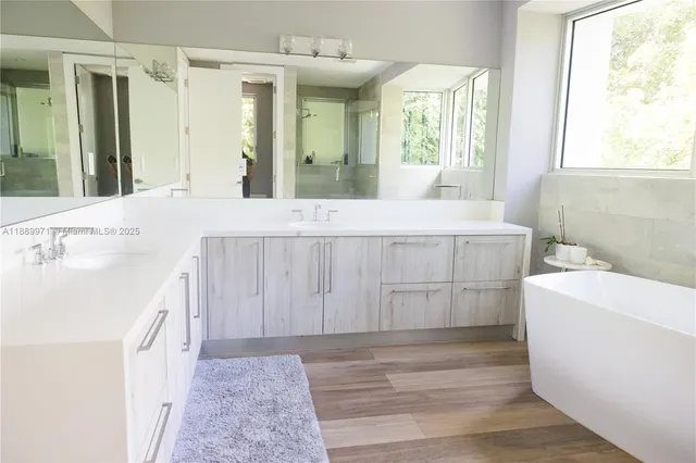 a spacious bathroom with a tub sink and mirror