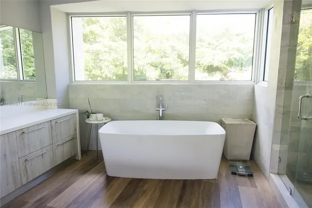 a white bath tub sitting in a bathroom next to a window