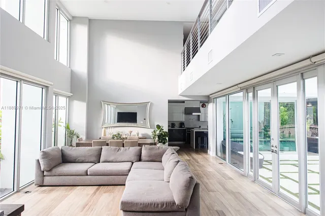 a living room with furniture large windows and a fireplace