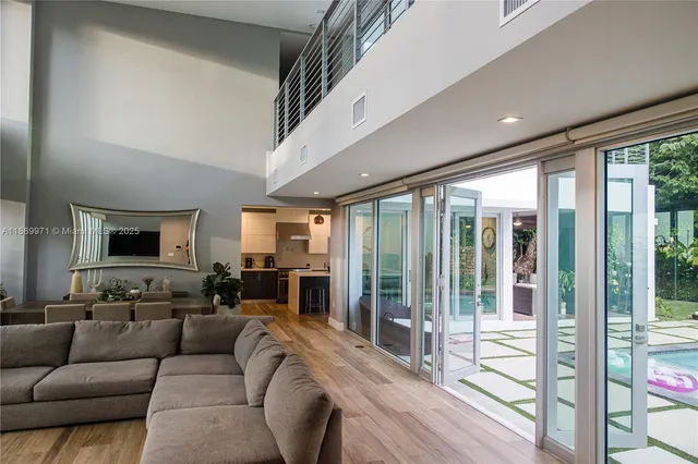 a living room with furniture large windows and a flat screen tv