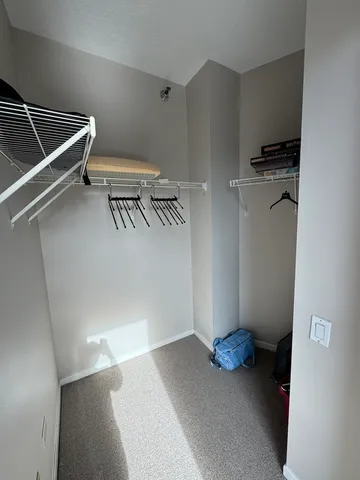 a view of walk in closet with clothes and shoes