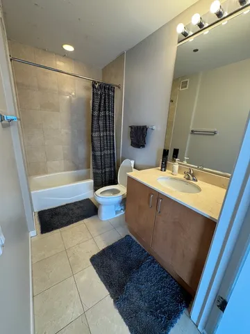 a bathroom with a sink a toilet a mirror and shower