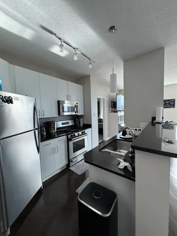 a kitchen with a refrigerator a stove a sink dishwasher and a stove with wooden floor