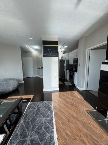 a large bedroom with a bed and a view of living room