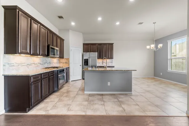 a large kitchen with kitchen island granite countertop a large counter top and sink