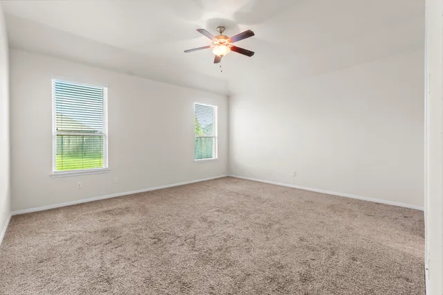an empty room with a window and a fan