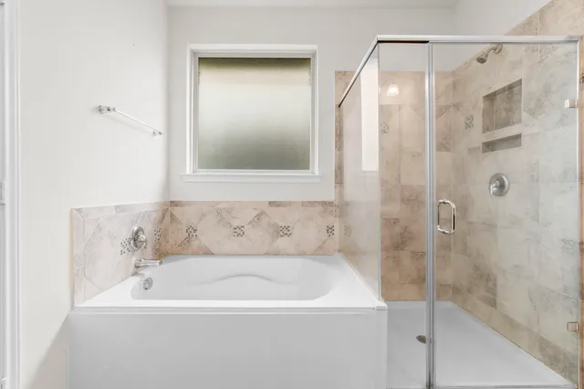 a white bath tub sitting next to a shower