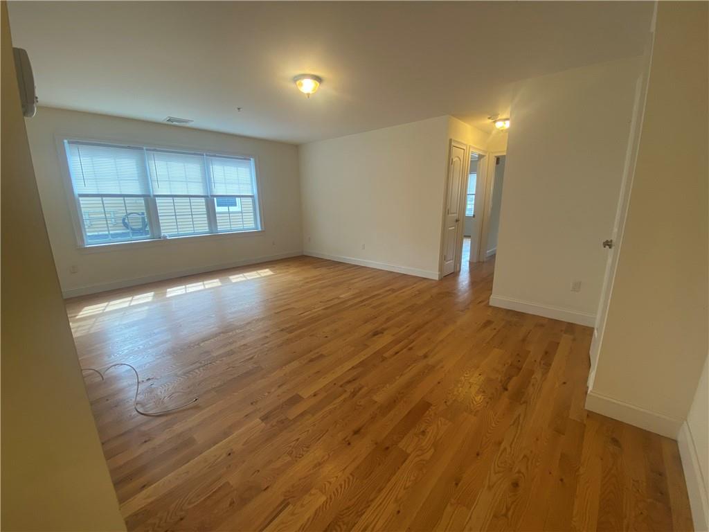 Empty room with light hardwood / wood-style flooring