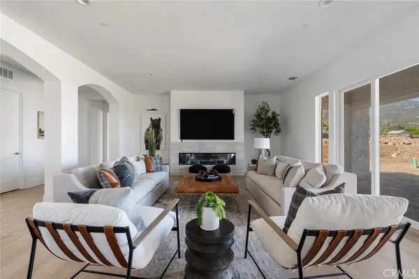 a living room with furniture a flat screen tv and a dining table