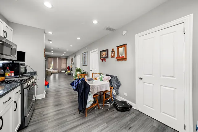 a view of kitchen with cabinets stainless steel appliances and dining table