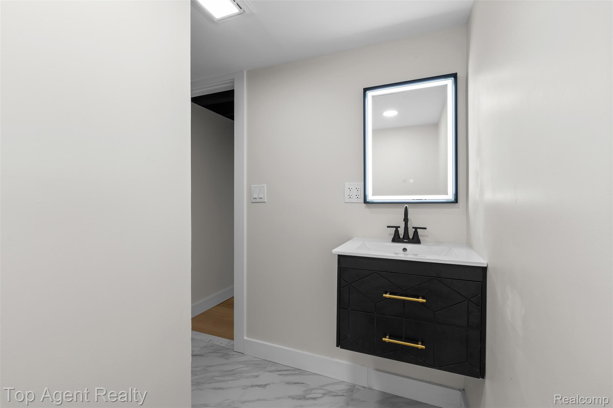 29863 Fall River Road Southfield, MI 48076 - Photo 31 of 50 Floating vanity featuring geometric paneling, gold-tone hardware, and a matte black faucet