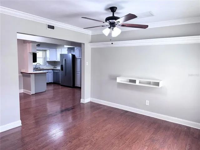 a kitchen with stainless steel appliances a refrigerator and a hard wood floor