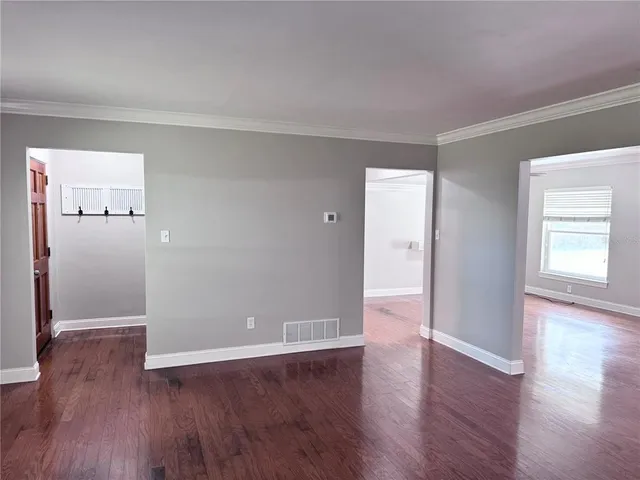 a view of a big room with wooden floor and windows