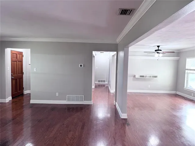 a view of an empty room with wooden floor