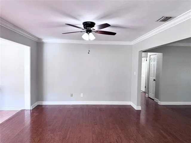 a view of an empty room with wooden floor