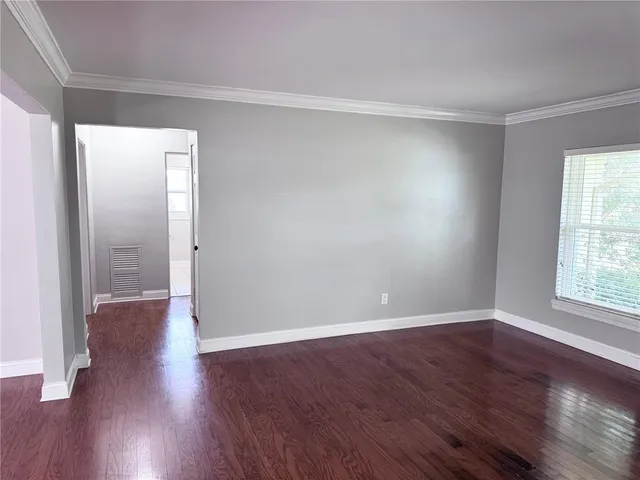 a view of empty room with wooden floor