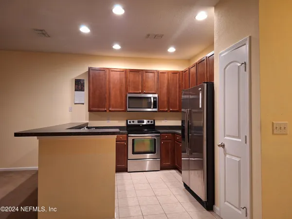 a kitchen with stainless steel appliances granite countertop a refrigerator and a stove top oven