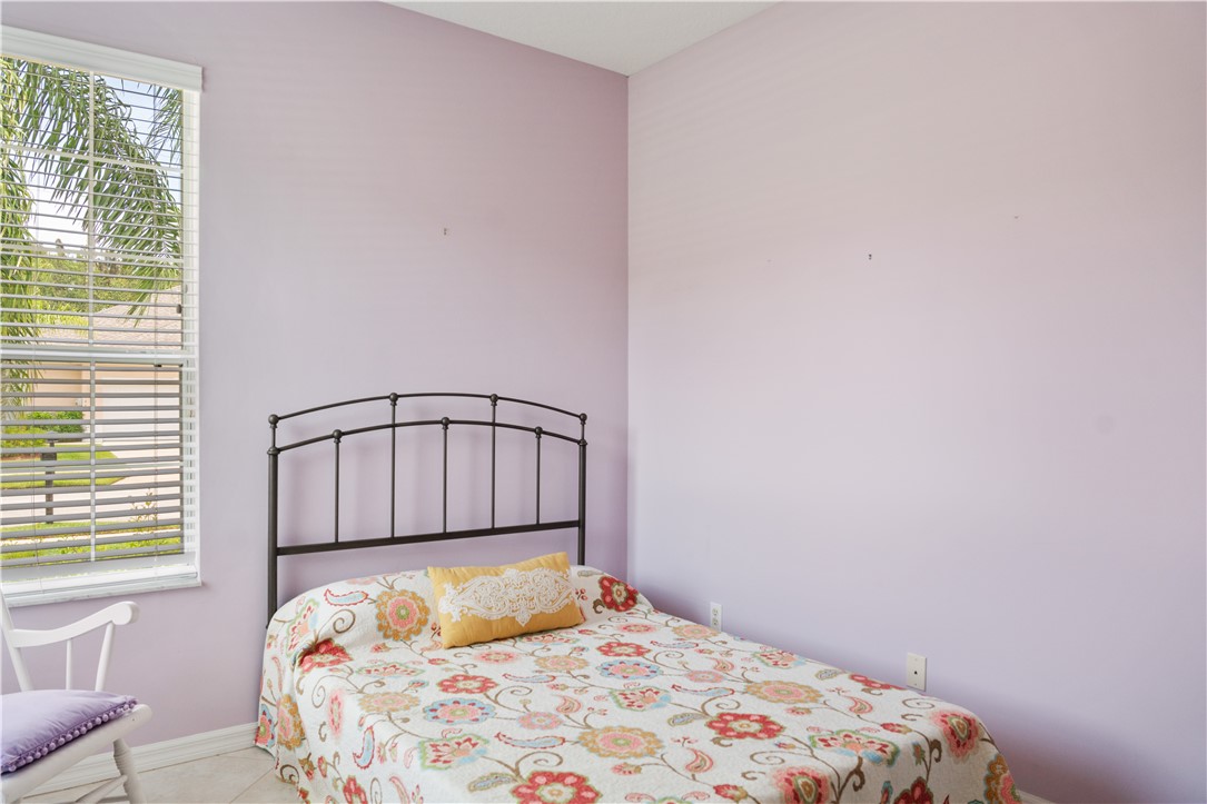 412 North Tangerine Square Southwest Vero Beach, FL 32968 - Photo 18 of 35 a bedroom with a bed and a window