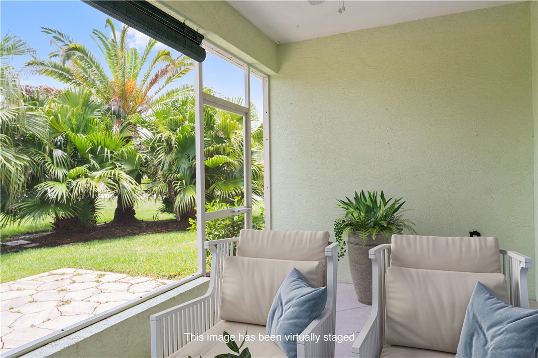 412 North Tangerine Square Southwest Vero Beach, FL 32968 - Photo 22 of 35 a living room with a couch and a floor to ceiling window